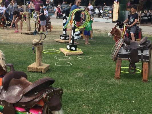 Jeux en bois traditionnels pour enfants lors d'une fête locale, animation ludique et intergénérationnelle en extérieur