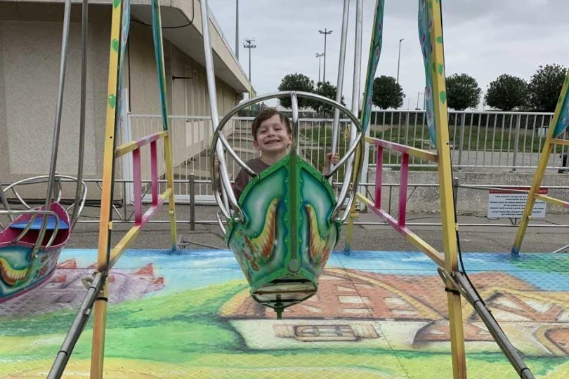 Enfants profitant d'un manège écoresponsable propulsé par les parents lors d'un séminaire d'entreprise durable