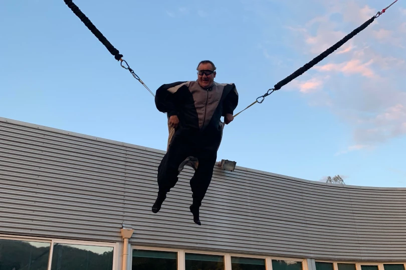 Participant expérimentant un simulateur de chute libre en extérieur lors d'un séminaire d'entreprise