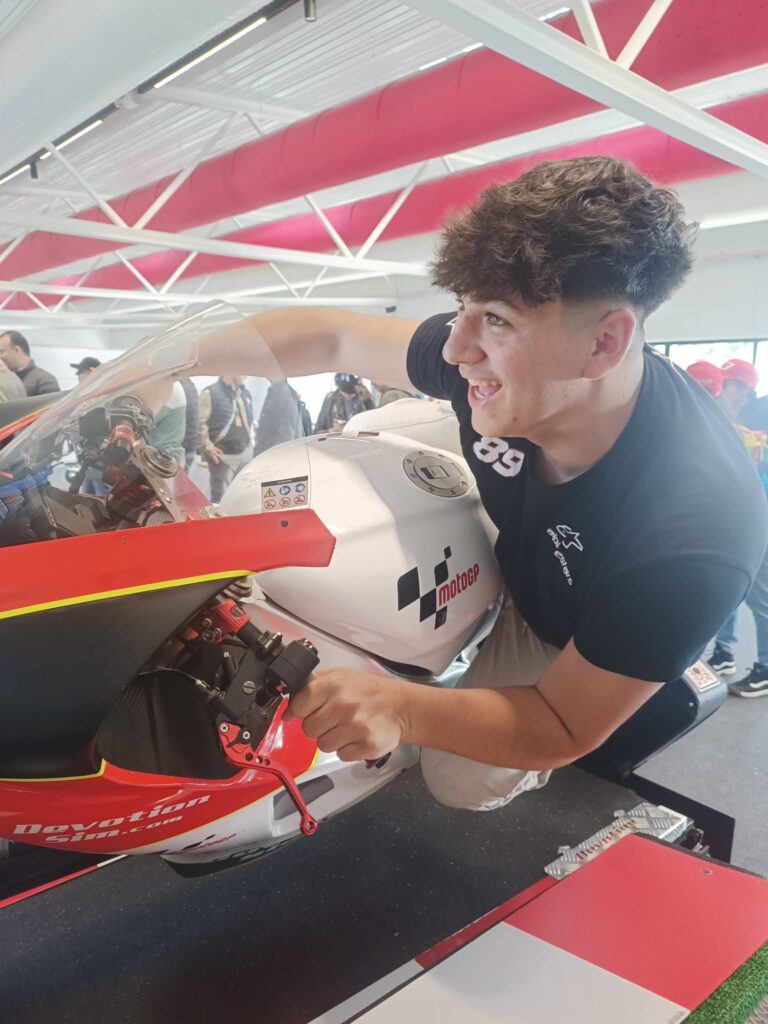 Conducteur portant un casque de moto en train de s’installer sur un simulateur de moto.